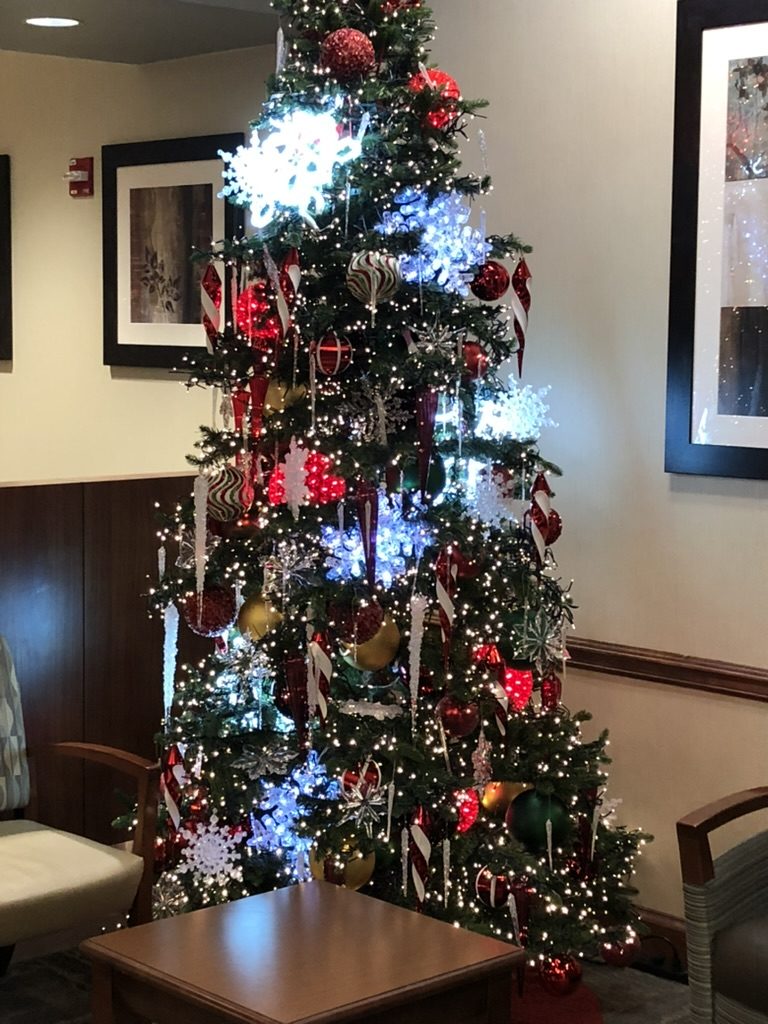Decorated tree in a lobby with glowing snowflakes, candy cane ornaments and red and gold balls